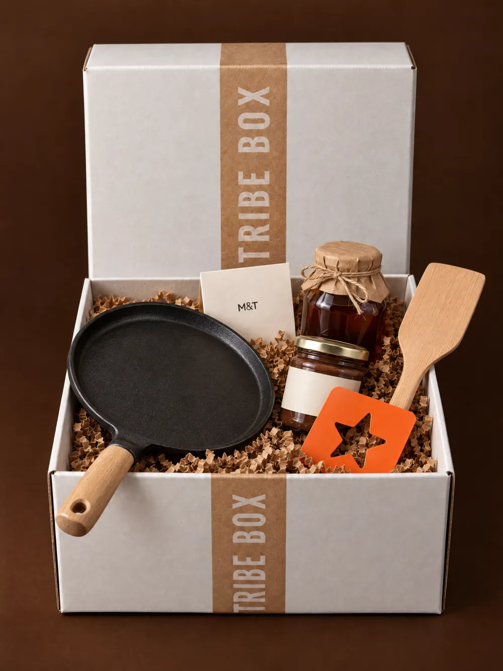 Een open Tribe Box met een pannenkoekenpan, stroop, smeerchoco en een spatel