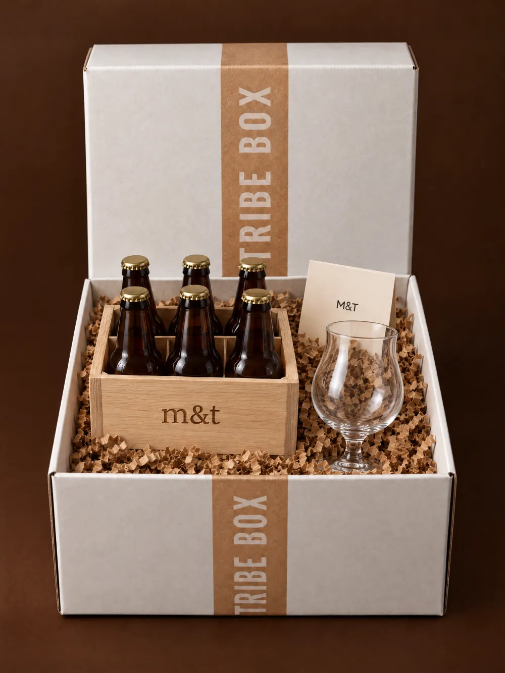 Een open Tribe Box met een eiken kistje met gravure, zes Belgische bieren en een proefglas