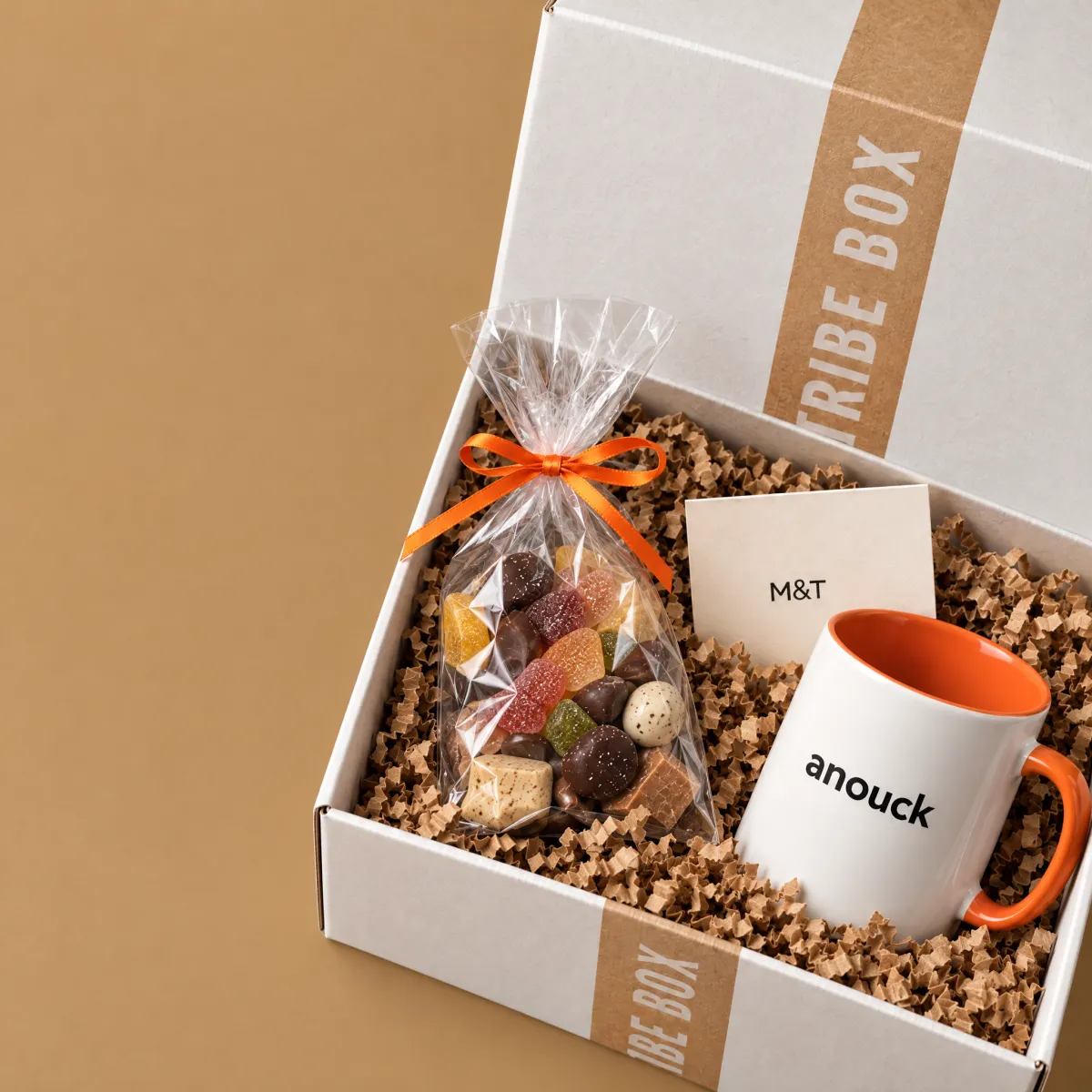 Een open Tribe Box van dichtbij, met de tas met naam, snoep en een kaartje