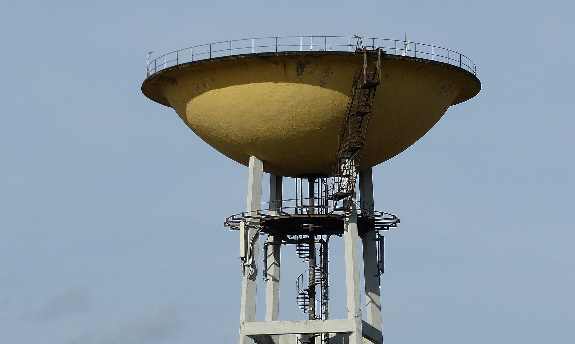 De gele watertoren op Corda Campus in Hasselt, tegen een blauwe lucht